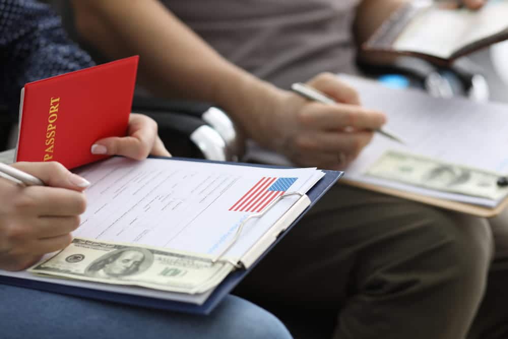 Couple reviewing immigration paperwork and passport while preparing a marriage-based adjustment of status application after a visa overstay