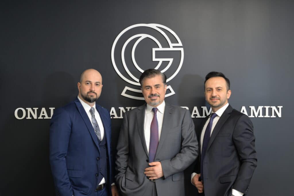 Onal Gallant Aramyan Amin attorneys standing in front of the firm's office signage